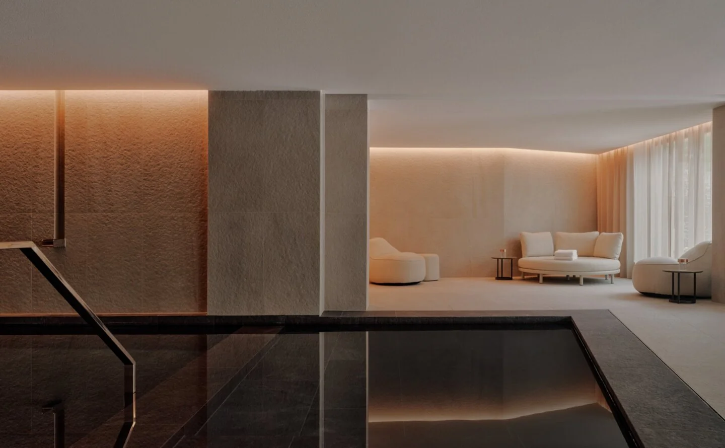 Cinematic shot of a luxury spa pool with deep blue-green water and atmospheric mist